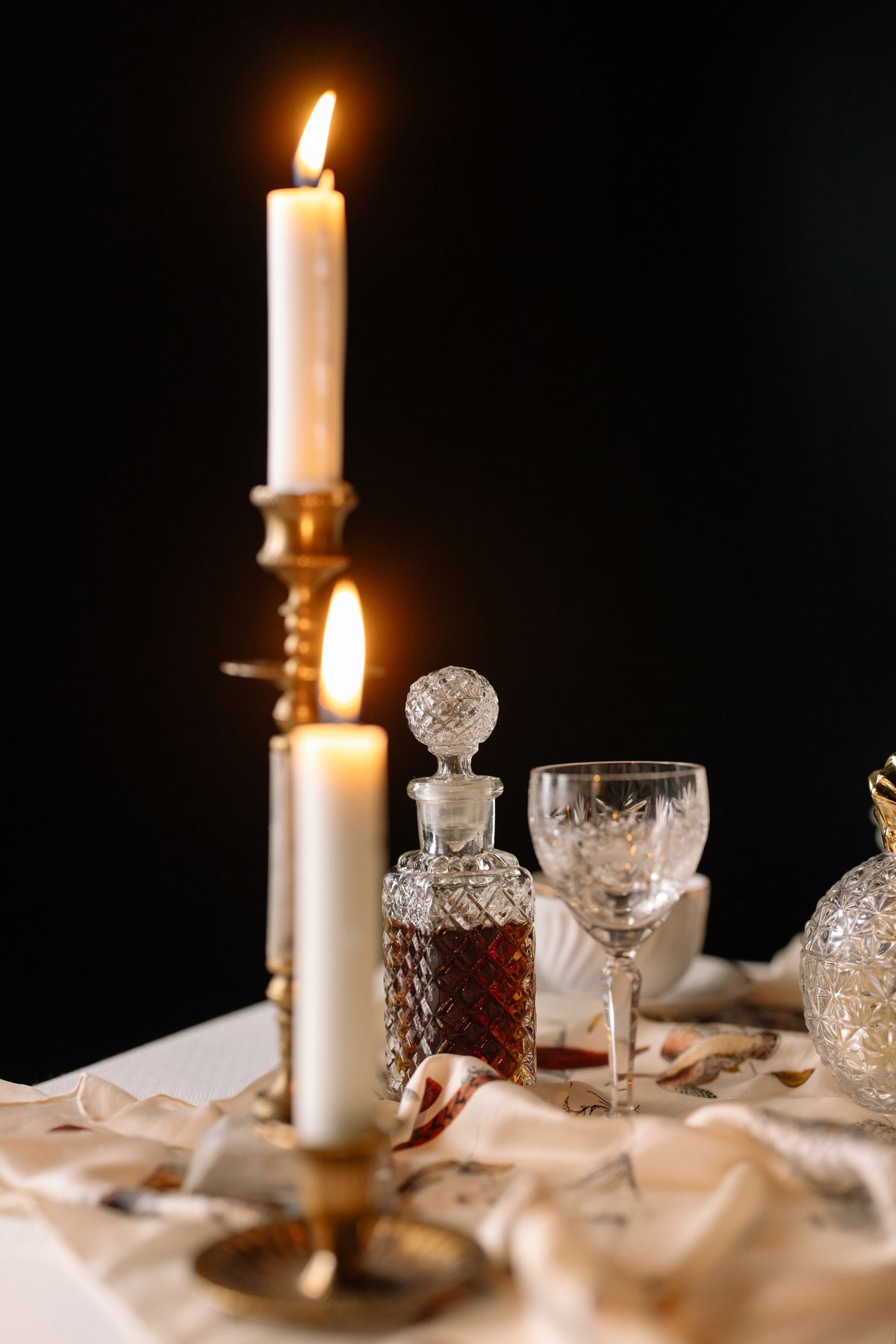 Carafe et verre en cristal à la lueur de deux bougies